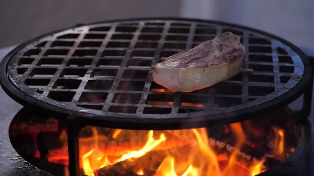 slow motion. steak fried on the charcoal grill. close-up
