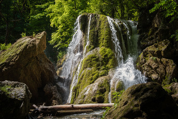 Obraz premium A beautiful waterfall deep in the forest, steep mountain adventure in the rainforest.