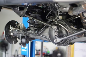 Obraz premium Suspension of drive car with new tire and Shock Absorber.Rear suspension of a modern car. Elements and design of the rear suspension. Rear suspension beam, spring, shock absorber.Close up.