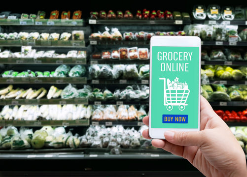 Online order grocery shopping on touch screen concept. Woman hand holding smart phone for ordering food delivery ingredients service at home for cooking. Business and technology for lifestyle in city.