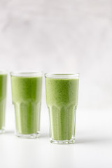 Green detox juice on white marble background with copy space. Vegan detox concept.