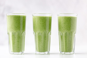 Green detox juice on white marble background with copy space. Vegan detox concept.