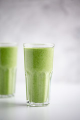 Green detox juice on white marble background with copy space. Vegan detox concept.