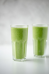 Green detox juice on white marble background with copy space. Vegan detox concept.