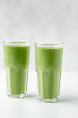 Green detox juice on white marble background with copy space. Vegan detox concept.