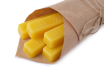 Beeswax wrapped in kraft paper on a white background. Beeswax blocks. Natural beeswax.