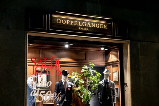 The storefront of the Doppelganger boutique which sells luxury menswear. Thw word saldi represents discount in Italian
