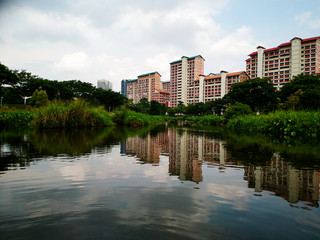Fototapeta na wymiar reflections of residential buildings in the pond of a neighborhood park
