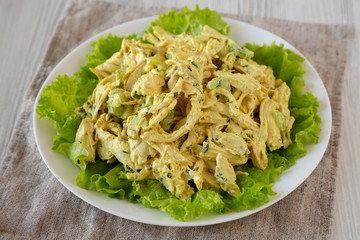 Homemade Curried Coronation Chicken Salad on a white plate, low angle view. Close-up.