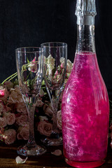 Sparkling brilliant raspberry drink. Champagne in two glasses stands on a wooden table with ice....