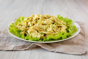 Homemade Coronation Chicken Salad on a white plate, low angle view. Close-up.
