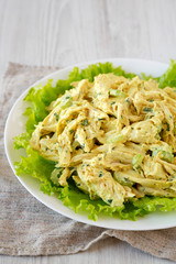 Homemade Coronation Chicken Salad on a white plate, low angle view.
