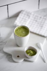 Matcha green tea latte in a rustic cup.