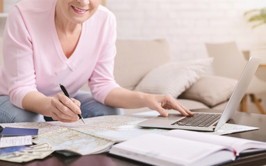 Senior woman choosing route on map at home