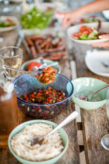 Dinner is served at a wooden table on the veranda with a spoon serves a snack from a glass salad bowl in the Provencal style Villa