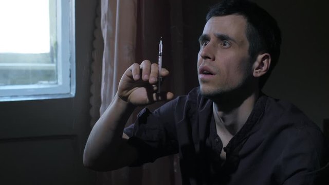 Addict making syringe injection of heroin