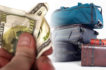 A crumpled hundred-dollar bill in his hand against the background of many suitcases. Payment for...