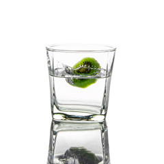 sliced kiwi fruit splashing falling in water glass isolated on white background
