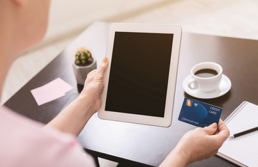 Elderly lady buying goods online on digital tablet