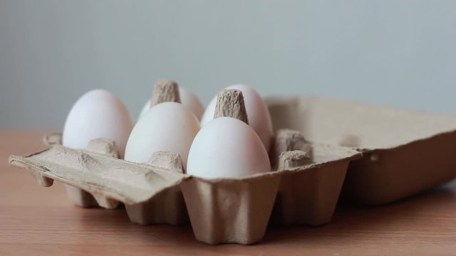 Woman hand taking egg to box.  