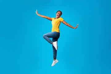 Fototapeta premium Positive African American Girl Jumping Posing Over Blue Background