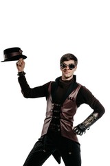 Steampunk actor in glasses and hat posing.
