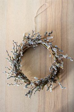 wreath of willow branches on a wooden table, top view, vertical frame