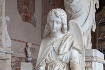 Fragment of an antique angel statue with a sad face