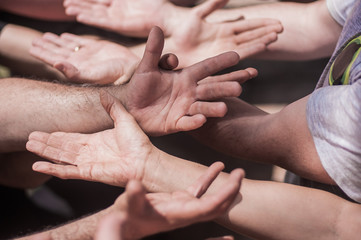 Large group of connected people holding empty open hands together