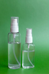 Bottle of hand sanitizer, antimicrobial liquid gel, germ prevention or antibacterial hygiene. Green background, for the prevention of coronavirus, a copy of the space