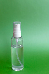 Bottle of hand sanitizer, antimicrobial liquid gel, germ prevention or antibacterial hygiene. Green background, for the prevention of coronavirus, a copy of the space