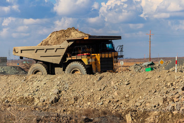 Huge yellow mining dump truck working in iron ore quarry. Mining industry © olyasolod
