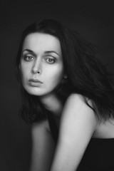 Fototapeta premium Portrait of a woman in black and white, she looks directly into the camera with her eyes wide open