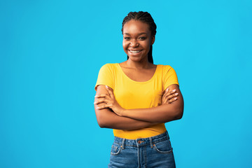 Confident Black Girl Smiling Crossing Hands Posing On Blue Background