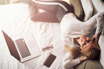 Businesswoman relaxing after meetings.Young beautiful woman working from a hotel room.