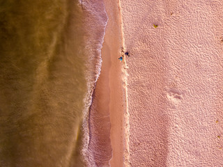 Aerial view of sandy beach and sea with waves