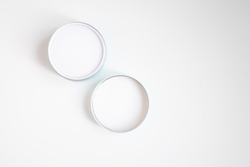 Closed jar of cream and lid on a white background top view