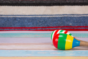 colorful Mexican maraca put on light color wooden floor