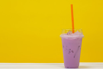 purple beverage and purple straw on yellow background