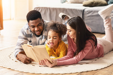 Daughter is reading book to her international parents