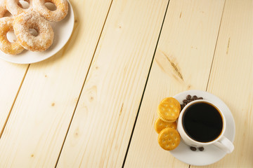coffee cup with beans, donuts and biscuits on wooden desk. flat lay. copy space for your text