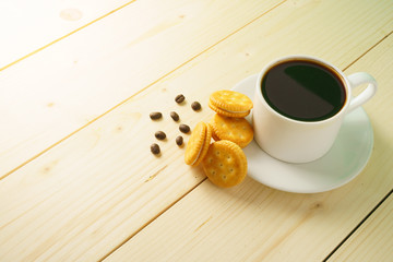 coffee cup with beans and biscuits on wooden desk. copy space for your text