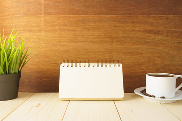 coffee cup with beans and office supplies on wooden desk against wood background. copy space for your text