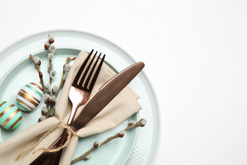 Festive Easter table setting with floral decor on white background, top view