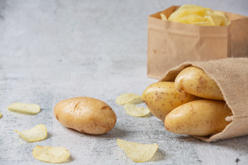 Potatoes pour out of sacks on gray floor