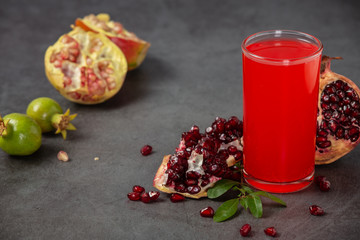 A glass of pomegranate juice with fresh pomegranate