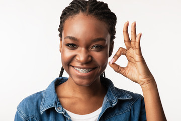 Girl With Braces Gesturing Okay Smiling To Camera In Studio