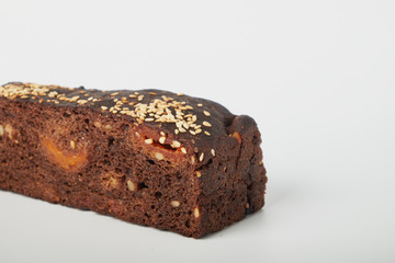 fresh bread with various seeds (pumpkin, dried apricots, flax, sunflower, sesame, prunes) is decorated with wheat ears isolated on a white background.