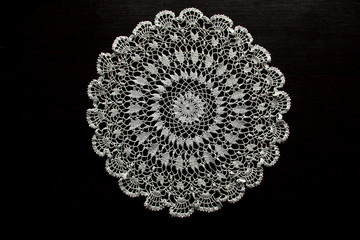 Crocheted napkin on a dark table - obrazy, fototapety, plakaty