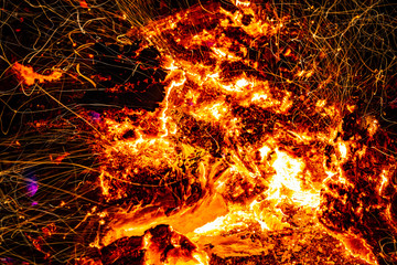 Fire in a bonfire close-up. Sparks from coal. Heat. Inferno. Macro photo.